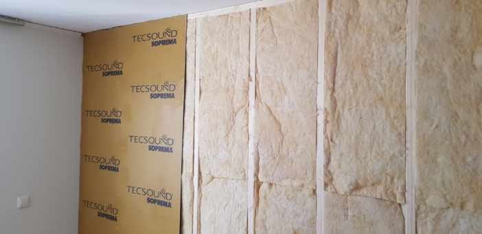 Isolering läggs i väggen mellan reglarna och Tecsound monteras på utsidan.